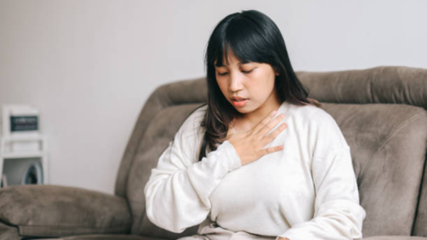 Woman struggling to breathe, a potential heart attack symptom.