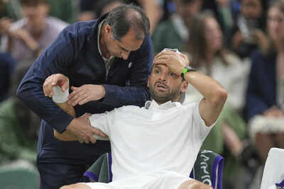 Grigor Dimitrov receiving medical attention after injury forces him to retire.